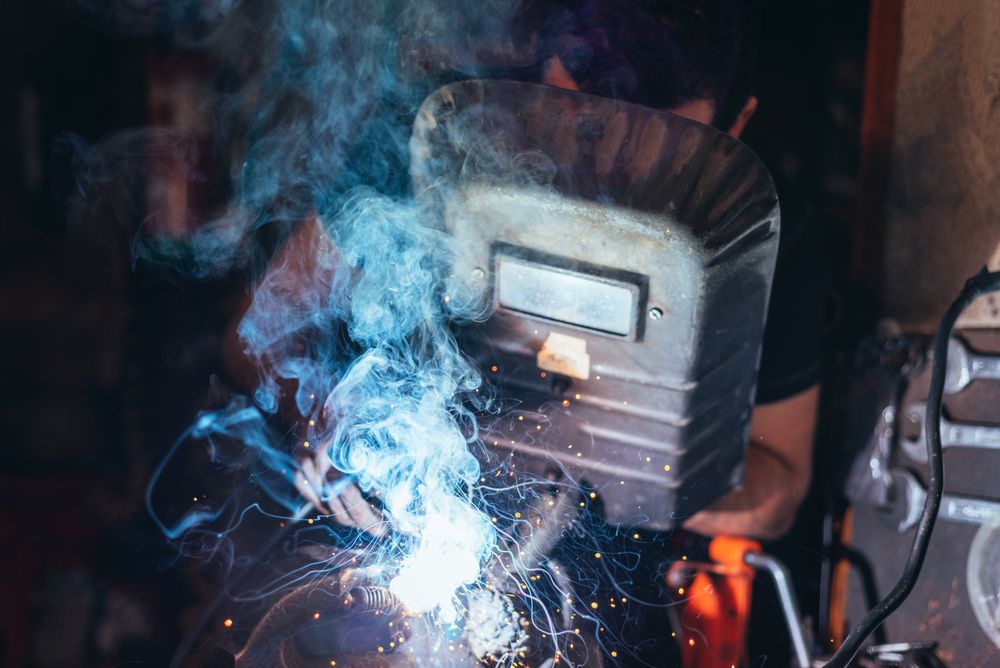 Professional welder in mask welding metal