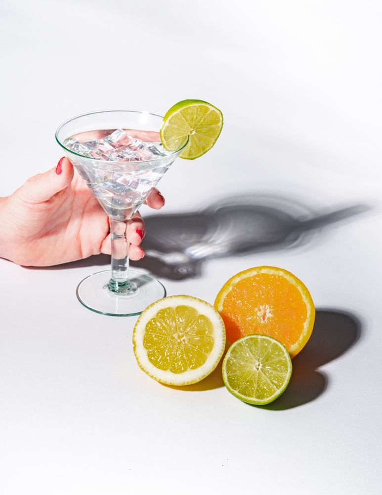 Cocktail glass with ice cubes and sliced citrus