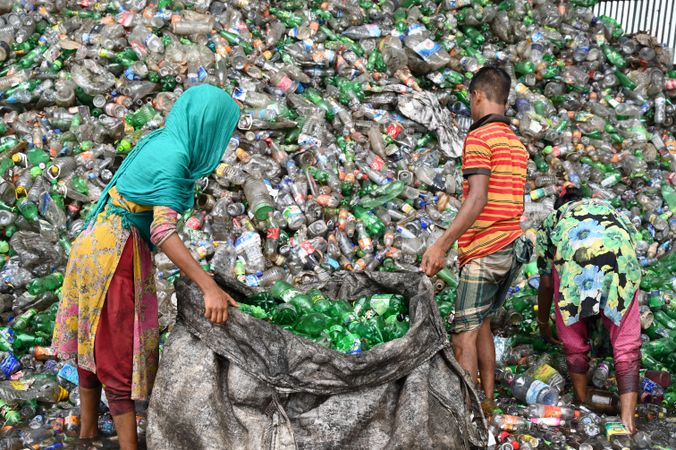 Young people collecting plastic bottles for recycling