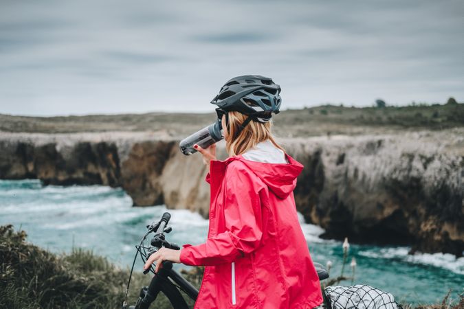 Female bicyclist holding sport bottle