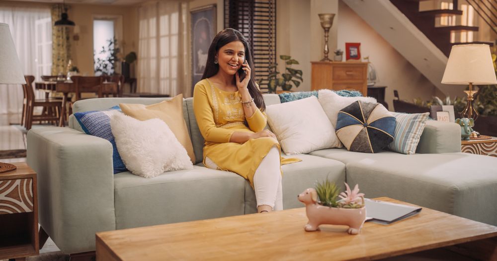 Indian Woman Engaged in a Lively Phone Call at Home: Discussing Work Matters with Colleagues or Clients.