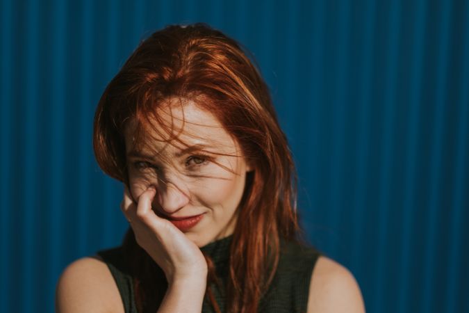 Smiling woman squinting in sun and enjoying weather