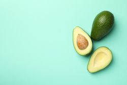 Ripe fresh avocado on mint background, top view