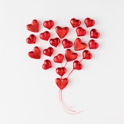 Heart made of red foil hearts on light background
