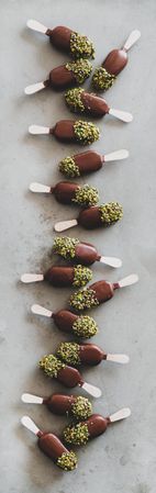 Ice cream chocolate pistachio popsicles, grey background