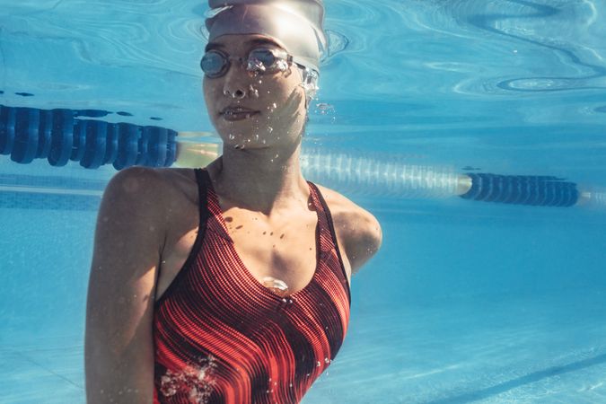Woman swimmer inside the pool turning while swimming