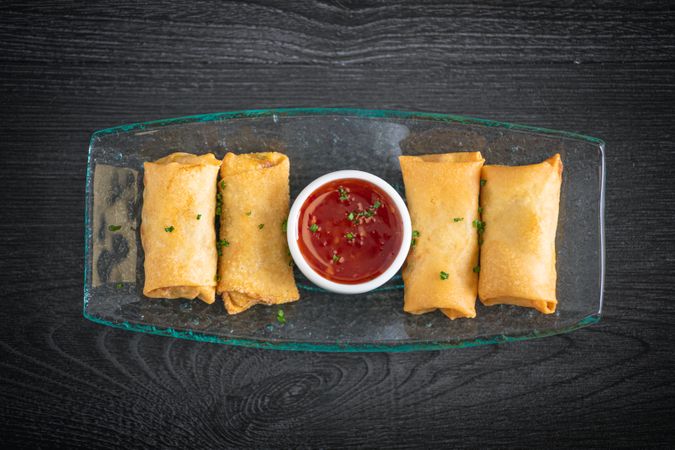 Vietnamese rolls with sweet chili on glass plate