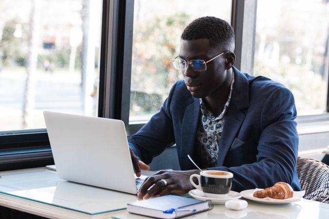 Black man working on laptop in cafe