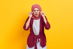 Stern woman in red headscarf and glasses looking at camera