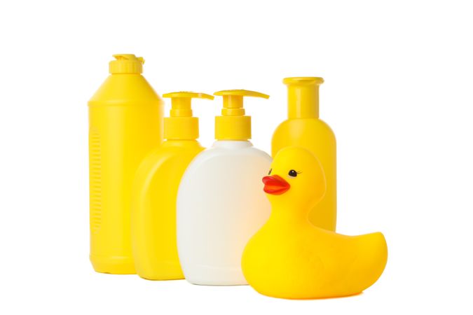 Bathroom bottles and rubber duck isolated on light background