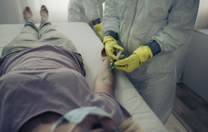 Doctor injecting antiviral to a sick patient