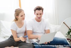 Young couple relaxing at home with laptop and credit card 4AEGm4