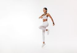 Young fit woman exercising over bright background