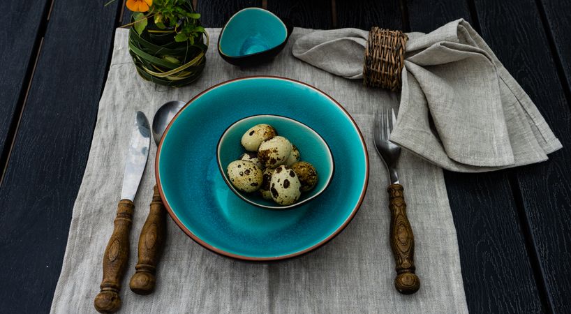 Easter table setting with teal plates and bowl of mini eggs