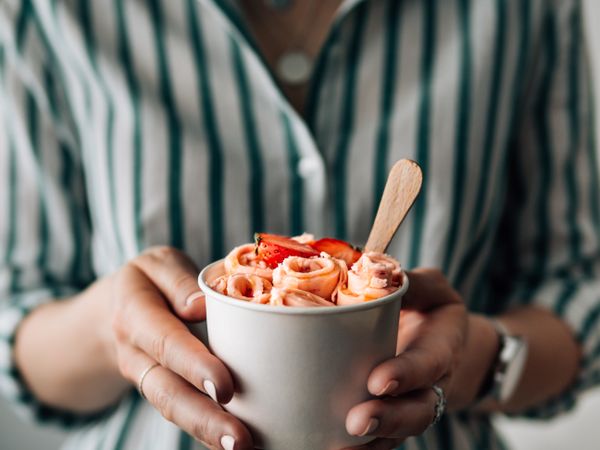 Hand holding rolled ice cream in cone cup