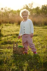 Smiling girl with basket standing on verdant grassy lawn