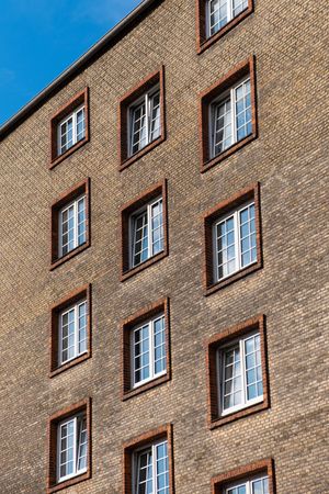 Close up of windows on minimal brown brick building under blue sky