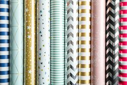 Rolls of festive wrapping paper as background. Top view