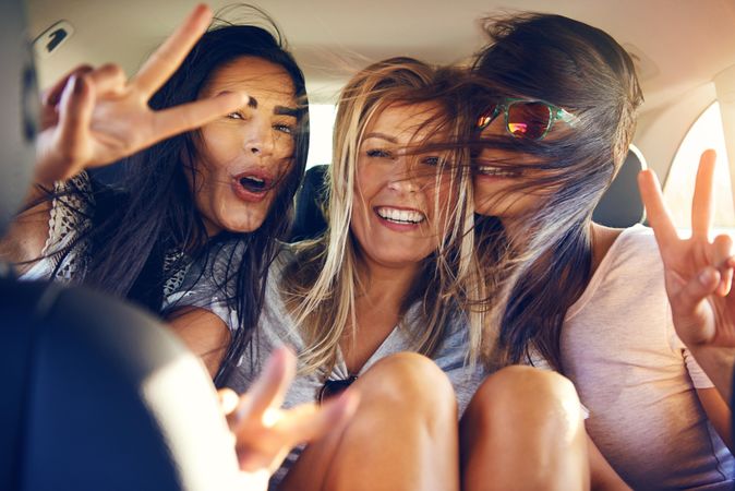 Group of female friends happy while riding in back of vehicle