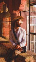 Man in cowboy hat sitting beside window in an ancient building