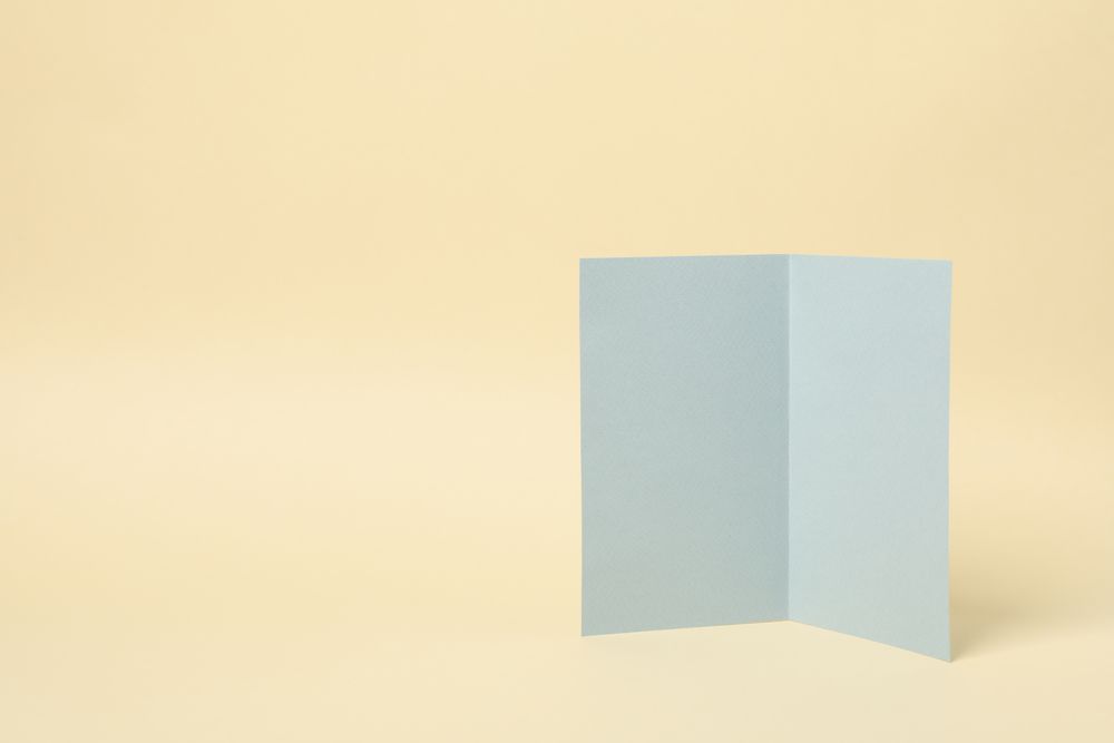 Light gray cardboard on beige background, space for text