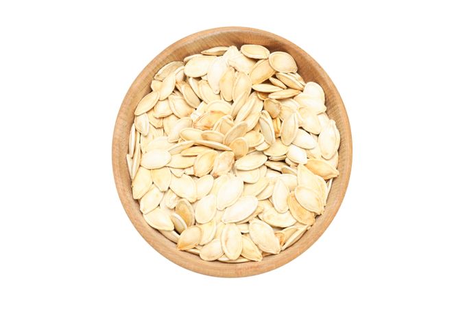 Fall season food - pumpkin seeds, isolated on light background