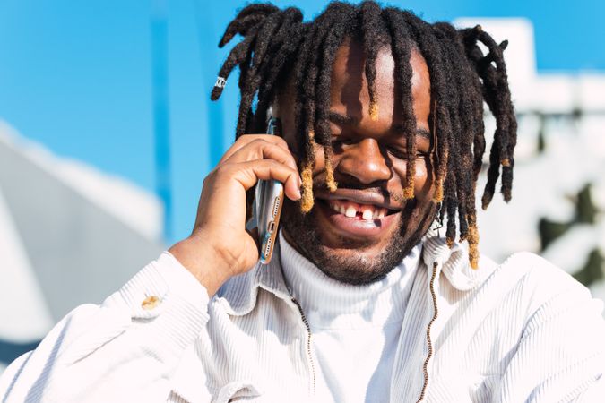 Cheerful Black man talking on smartphone