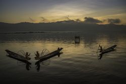 Fishermen on their boats at sunset in Myanmar