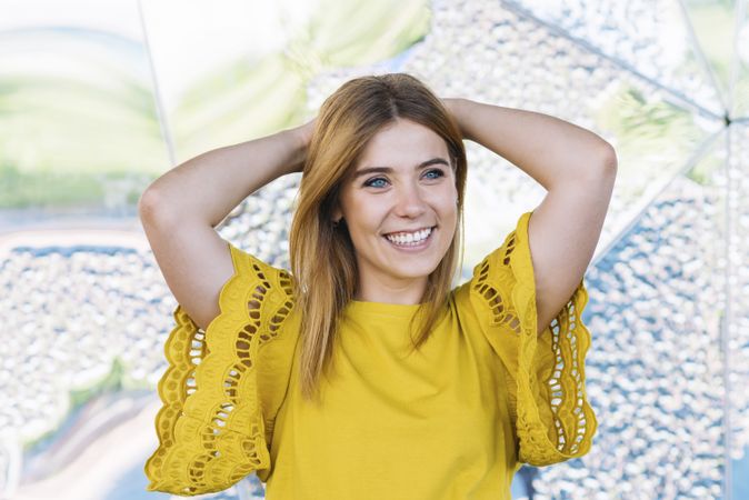 Young cheerful woman posing with hand in air