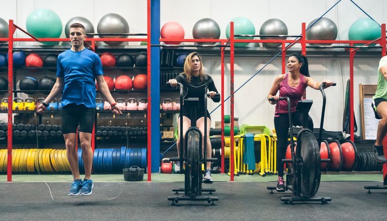Athletes doing air bike and skipping rope