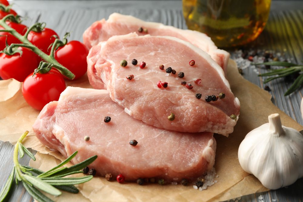 Composition with raw meat for steak and ingredients on wooden background