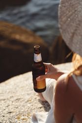 Woman relaxing and drinking beer at beach