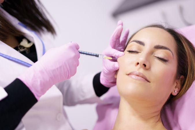 Woman having fillers injected into the side of her cheek