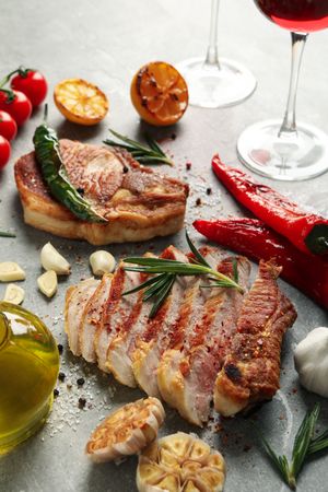 Composition with fried steaks, wine and vegetables. Grilled food