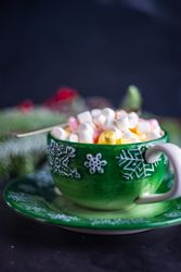 Side view of green cup with marshmallow drink