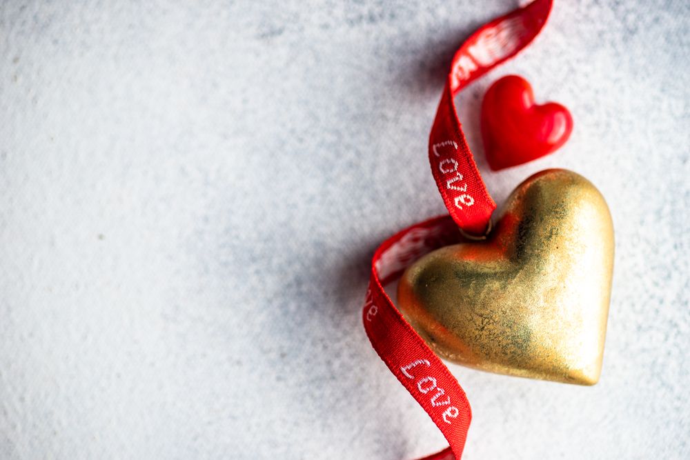 St Valentine day concept with gold and red decorations with space for text