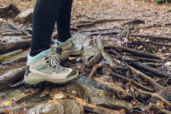Legs of traveler in casual outfit exploring autumn forest