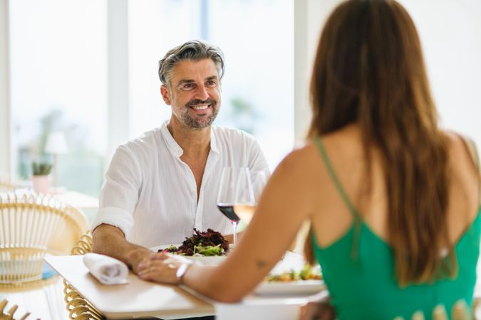 Happy couple holding hands in restaurant
