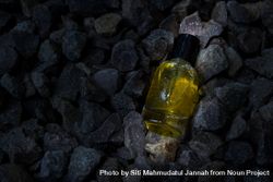 Yellow perfume bottle mock up laying in the rocks 4jVElR