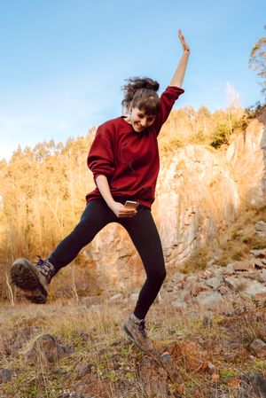 Young woman with smartphone dancing