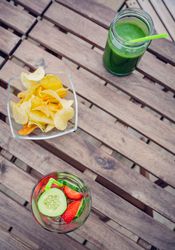 Top view of snacks and drinks on empty table outside