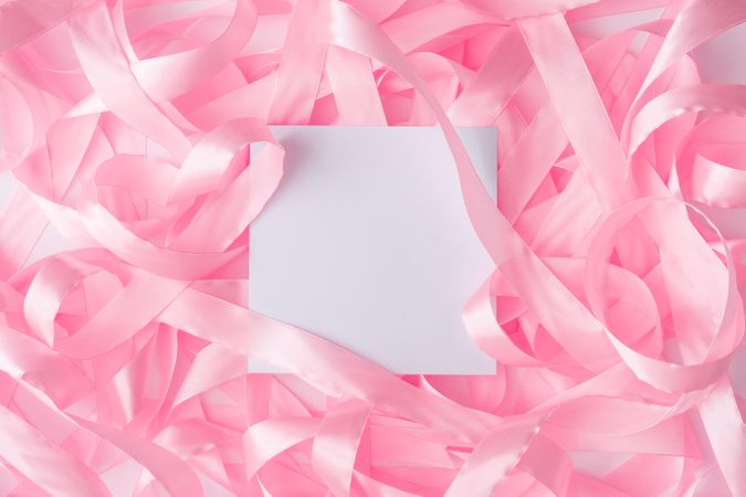 Pink satin ribbon background with paper card note