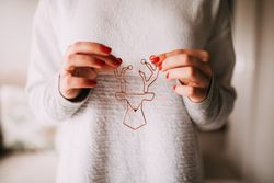 Woman holding a festive brass reindeer ornament