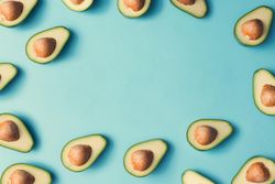 Avocado halves pattern bordering a pastel blue background