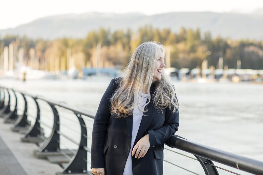Woman wearing a blazer leaning on a railing