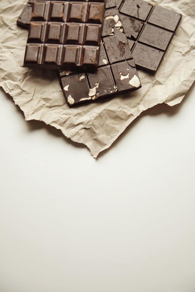 Top view of stack of three chocolate bars on paper with copy space