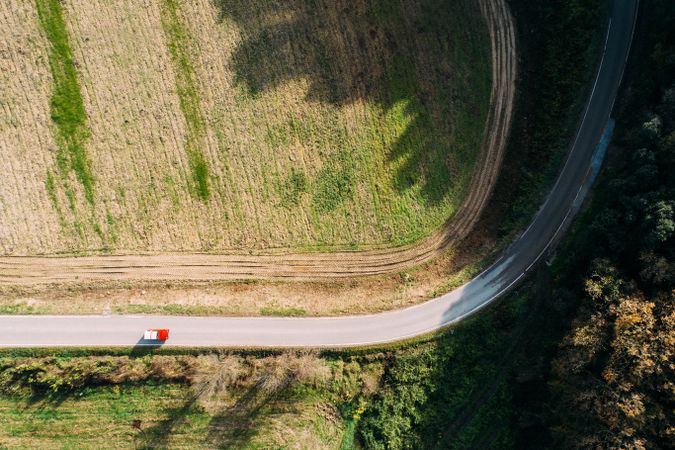 Van riding on countryside road near field