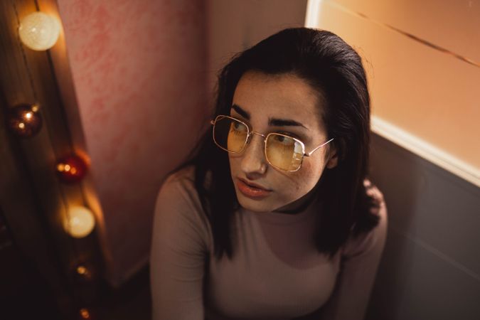 young woman portrait with yellow glasses posing