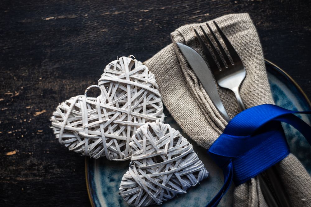 Blue ribbon wrapping cutlery with heart decorations