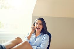 Woman using toothbrush in bright room